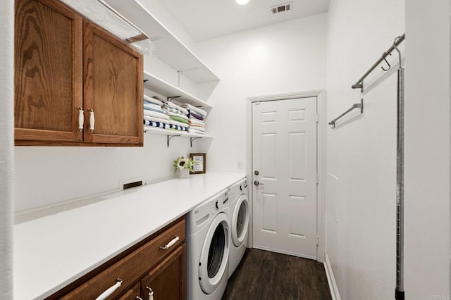 laundry room with cabinet space, visible vents, dark wood-type flooring, and washer and dryer