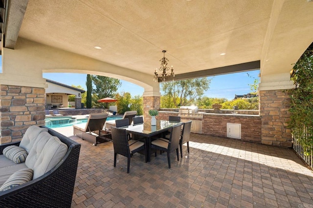 view of patio / terrace with exterior kitchen, outdoor dining space, and a fenced in pool