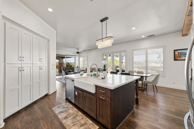 kitchen with visible vents, dishwasher, an island with sink, pendant lighting, and a sink