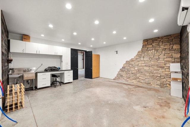 kitchen with concrete flooring, recessed lighting, white cabinets, and built in desk