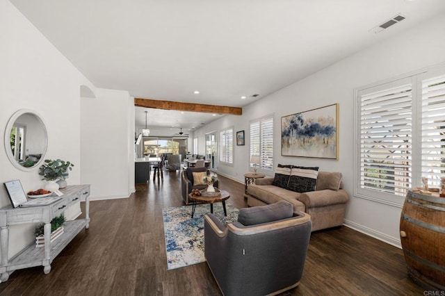 living area featuring dark wood-type flooring, visible vents, and baseboards