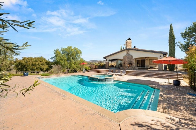 view of swimming pool featuring a pool with connected hot tub and a patio