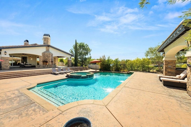 view of pool featuring an outdoor stone fireplace, a patio area, and a pool with connected hot tub