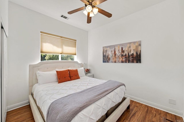 bedroom with dark wood-style flooring, a closet, visible vents, and baseboards