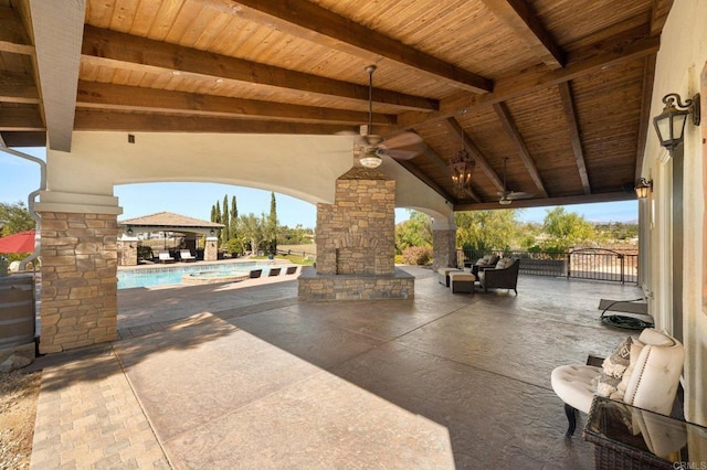 view of patio / terrace with an outdoor stone fireplace, an outdoor pool, and a gazebo