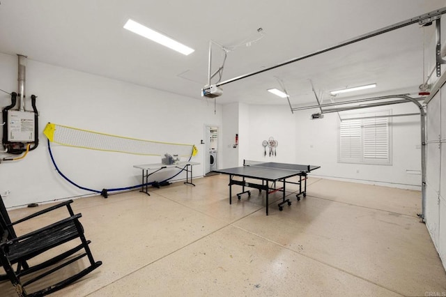 garage featuring water heater, separate washer and dryer, and a garage door opener