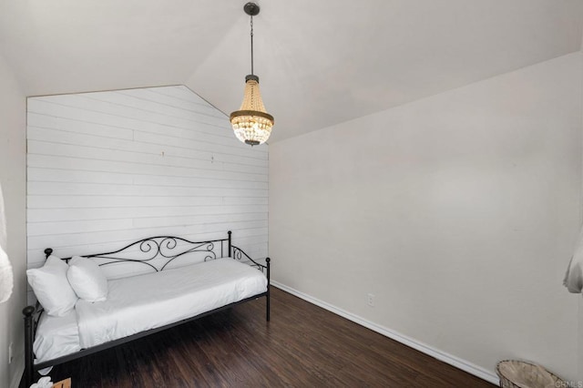 bedroom featuring vaulted ceiling, a chandelier, wood finished floors, and baseboards