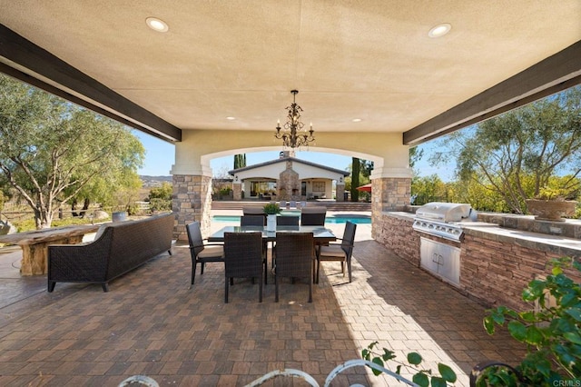 view of patio / terrace with an outdoor pool, outdoor dining area, exterior kitchen, and area for grilling