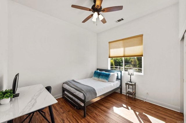 bedroom with baseboards, visible vents, ceiling fan, and wood finished floors