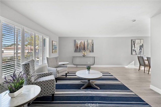 living area featuring light wood finished floors and baseboards