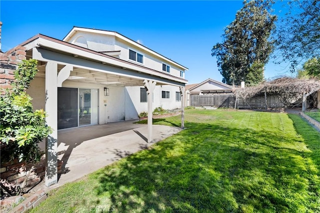 rear view of property featuring a fenced backyard, a lawn, a patio, and stucco siding