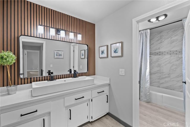 full bath with shower / bath combo, wood finished floors, vanity, and baseboards