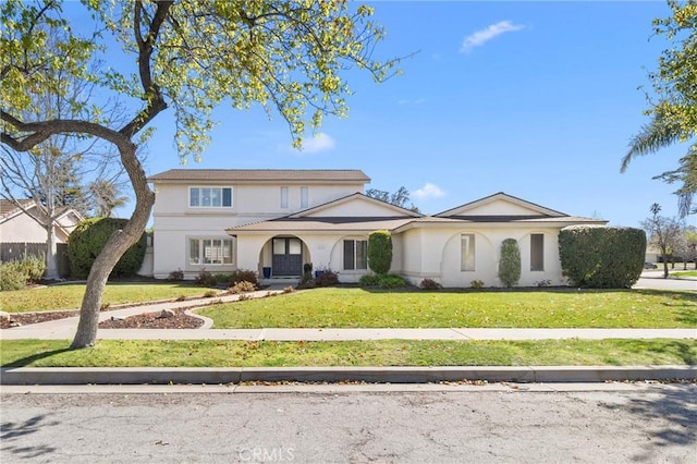 traditional-style house featuring a front yard and stucco siding