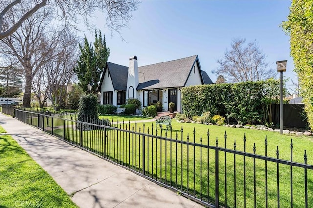 view of front of property featuring a fenced front yard, a chimney, a front lawn, and stucco siding