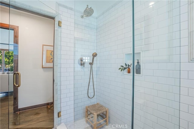 full bath featuring a stall shower and baseboards