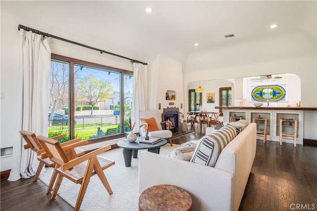 living room featuring a lit fireplace, dark wood finished floors, visible vents, and recessed lighting