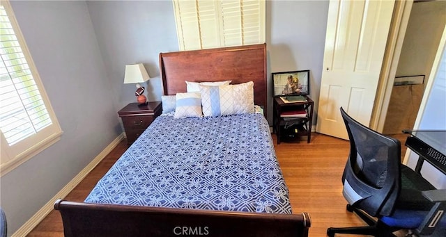 bedroom with baseboards and wood finished floors