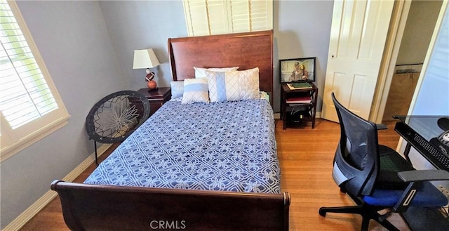 bedroom featuring baseboards and wood finished floors