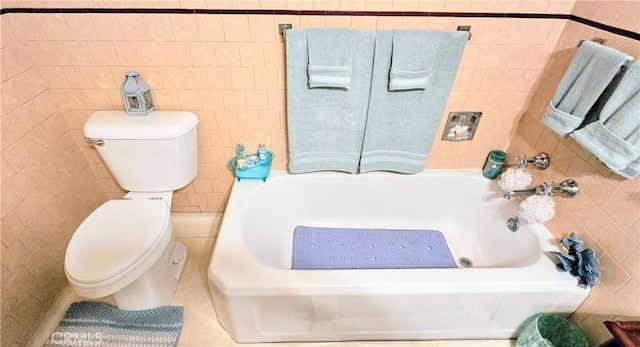 bathroom with tile patterned flooring, tile walls, and toilet