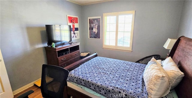 bedroom featuring baseboards and wood finished floors