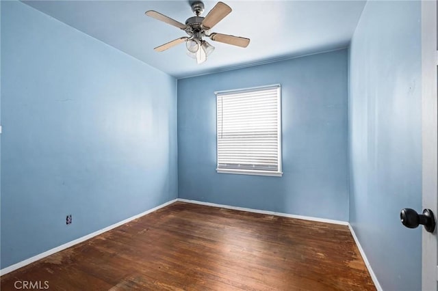 unfurnished room with ceiling fan, dark wood-type flooring, and baseboards