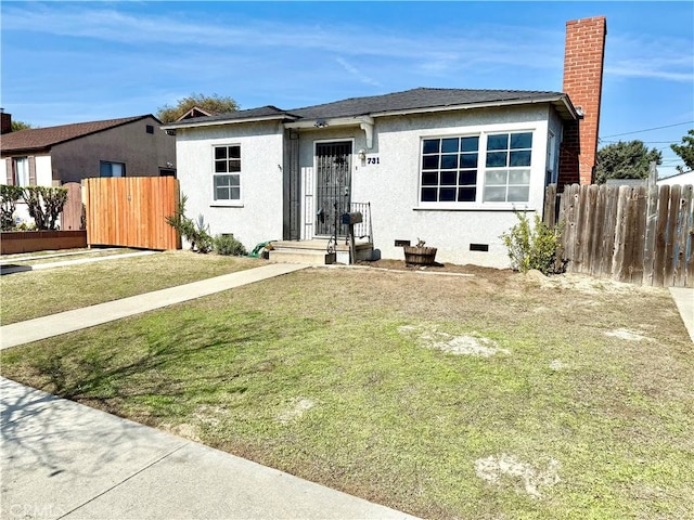 view of front facade featuring crawl space, a front yard, fence, and stucco siding