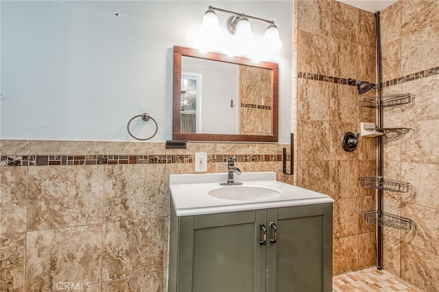 full bath with tile walls, a tile shower, and vanity