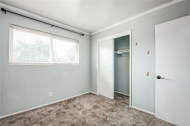 unfurnished bedroom featuring ornamental molding, a closet, light carpet, and baseboards