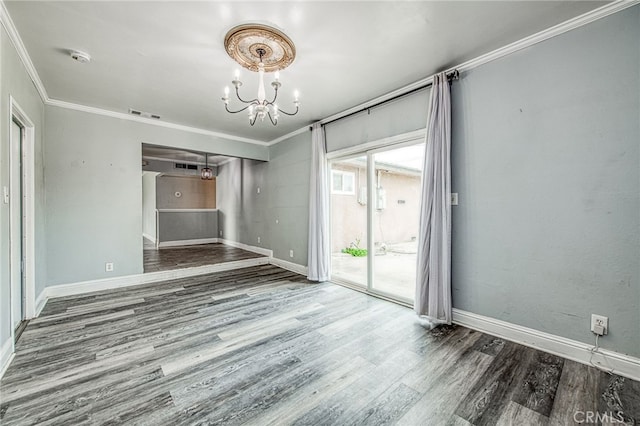 unfurnished room with ornamental molding, a notable chandelier, and wood finished floors