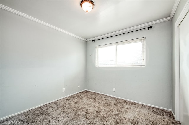 empty room with carpet floors, crown molding, and baseboards