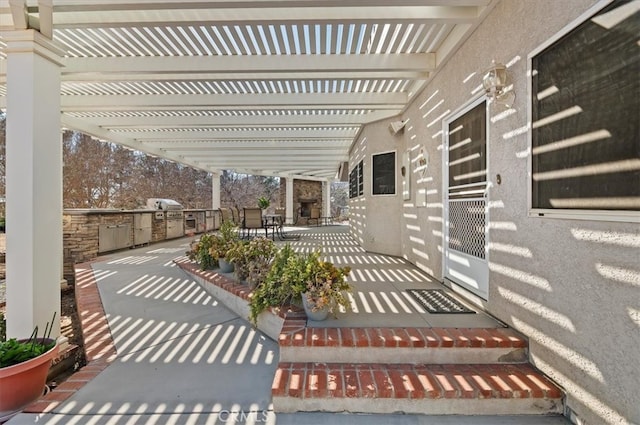 view of patio with area for grilling and a pergola