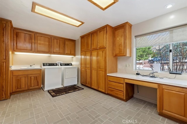 washroom featuring cabinet space, washing machine and clothes dryer, a sink, brick patterned floor, and recessed lighting