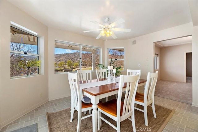 dining room with ceiling fan and baseboards