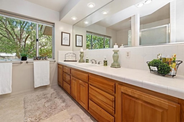 full bath with a stall shower, recessed lighting, backsplash, and vanity