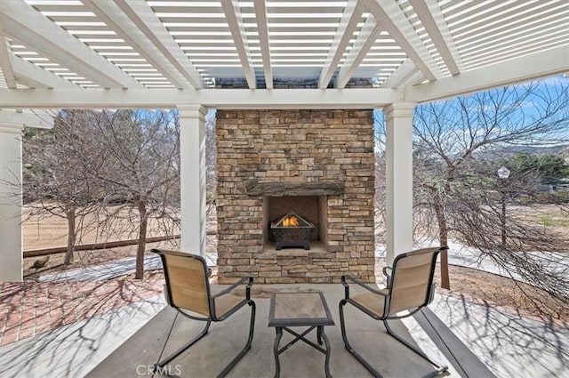 view of patio featuring an outdoor stone fireplace and a pergola