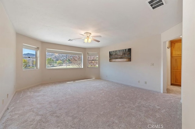 carpeted empty room with visible vents and ceiling fan