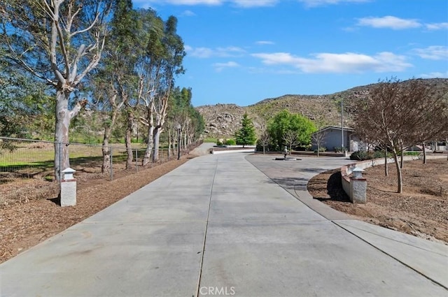 surrounding community featuring a mountain view and fence