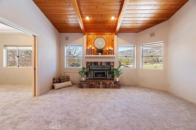 unfurnished living room featuring carpet floors, wooden ceiling, a large fireplace, and baseboards