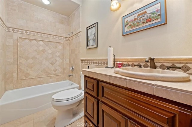 full bath with tile patterned flooring, toilet, vanity, tile walls, and shower / washtub combination