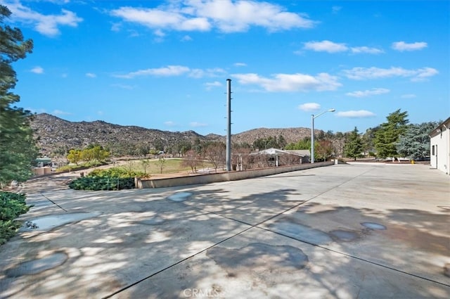 view of street featuring street lighting, a mountain view, and concrete driveway