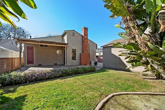 rear view of house featuring a lawn, a patio area, fence, and stucco siding