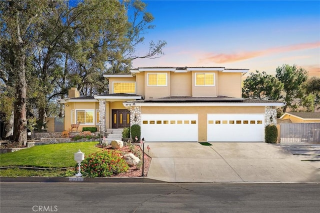 view of front of house with a garage, fence, concrete driveway, and a front yard