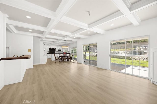 unfurnished living room with light wood-type flooring, coffered ceiling, and beam ceiling