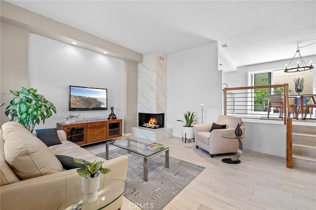 living room featuring a fireplace, wood finished floors, and a notable chandelier