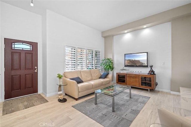 living area featuring baseboards and wood finished floors