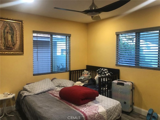 bedroom featuring ceiling fan, wood finished floors, and baseboards