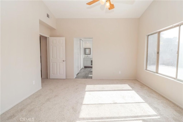 empty room featuring carpet, visible vents, and ceiling fan