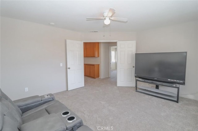 living area featuring visible vents, light carpet, and ceiling fan