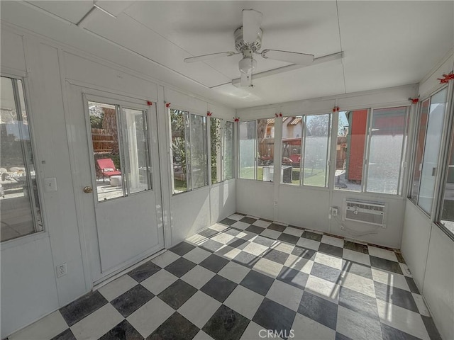 unfurnished sunroom with a wall mounted air conditioner and a ceiling fan