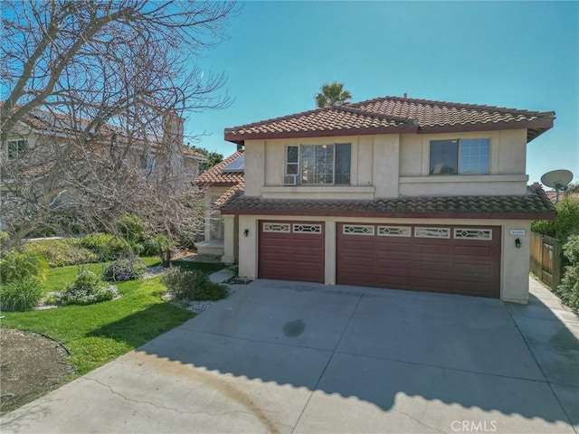 view of front facade with stucco siding, concrete driveway, an attached garage, and a tiled roof